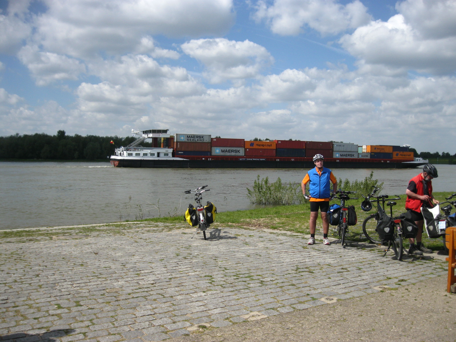 Horst postiert am Rheinufer und Containerschiff fährt vorbei
